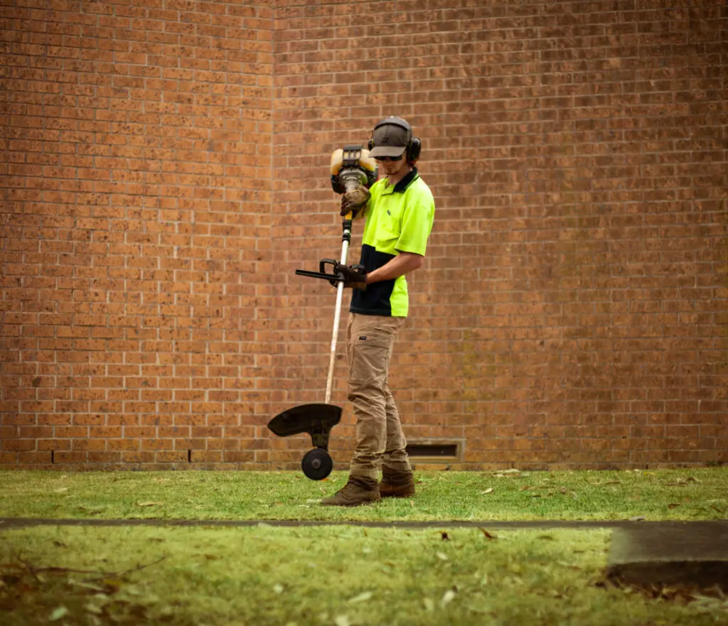 Young Brothers holding grass line trimmer