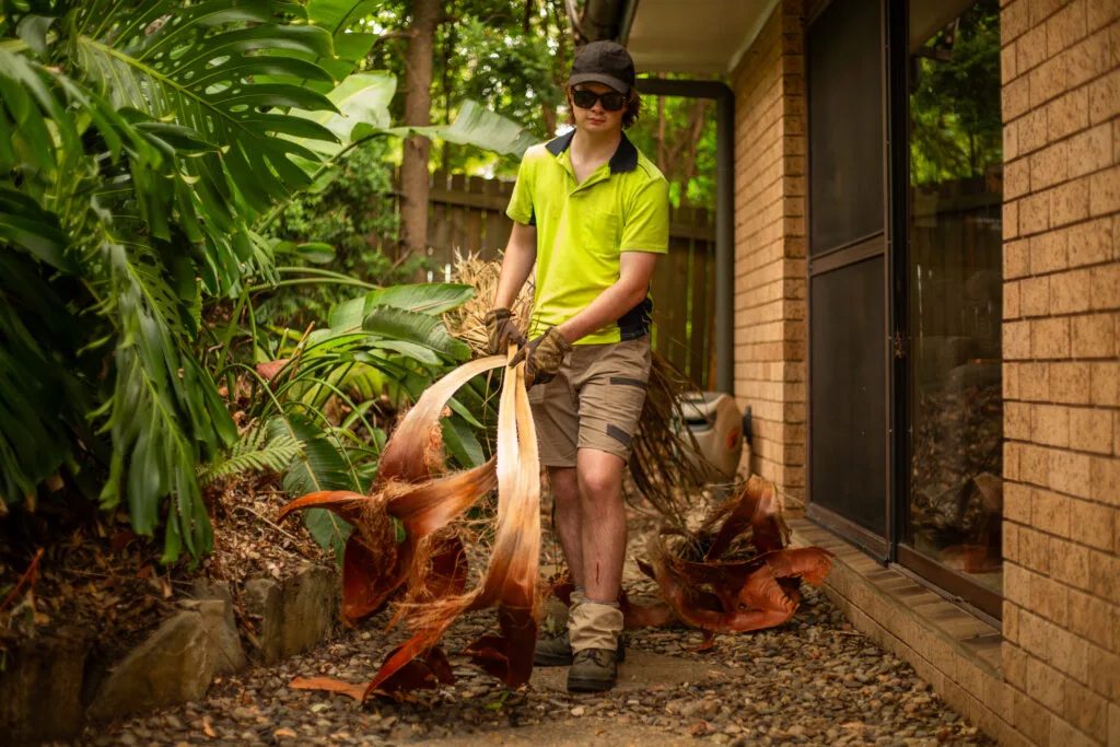 Young Brother removing vegetation from a clients garden